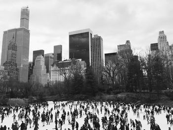 Panoramic view of skyscrapers against cloudy sky