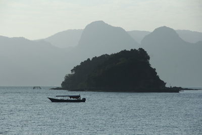 Scenic view of sea and mountains against sky