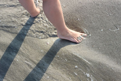 Low section of woman standing on beach