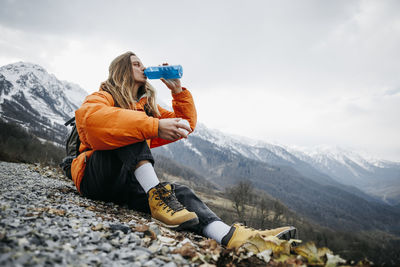 Man with blond hair drinking water on vacation