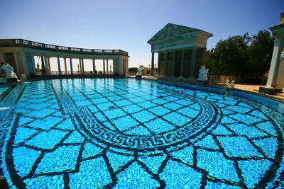View of swimming pool building against clear blue sky