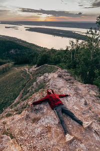 High angle view of man on mountain against sky during sunset