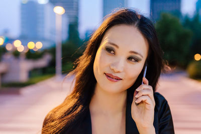 Portrait of smiling young woman in city