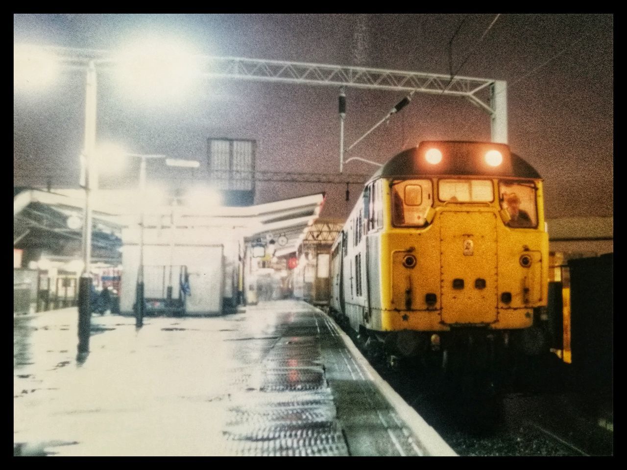 TRAIN ON ILLUMINATED STREET IN CITY AT NIGHT