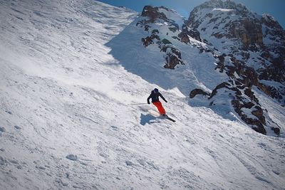 Low angle view of man skiing downhill on mountain