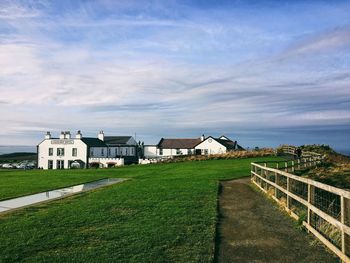 Houses by sea against sky