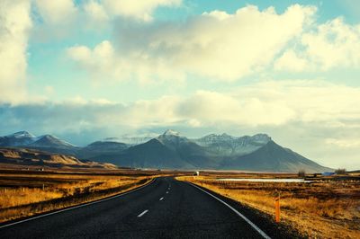 Empty road along countryside landscape