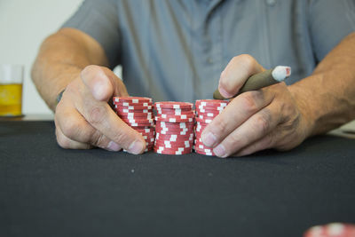 Man stacking gambling chips on table