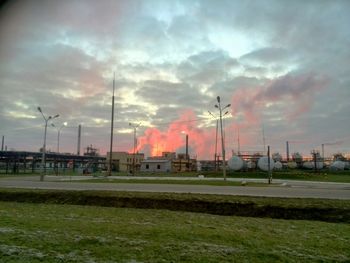 View of field against cloudy sky