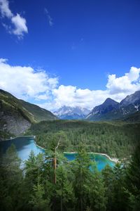 Scenic view of lake and mountains against blue sky