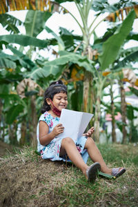 Full length of woman sitting on book