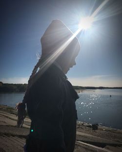 Woman standing at beach against sky