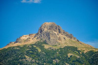 Low angle view of mountain against blue sky