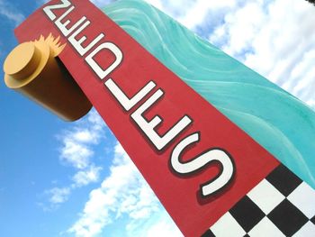 Low angle view of road sign against blue sky