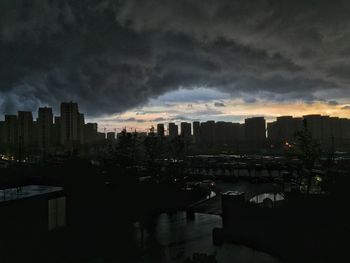 View of cityscape against cloudy sky