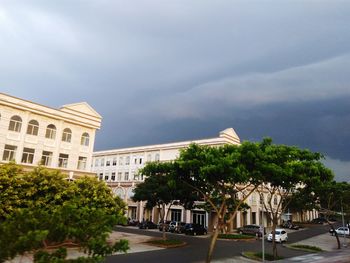 Buildings in city against cloudy sky