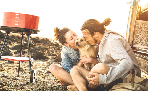 Couple with dog sitting on field