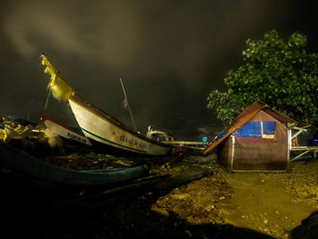 Abandoned boat moored on beach against sky