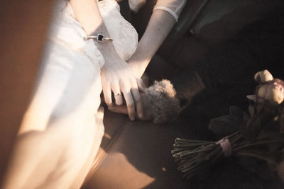 Midsection of wedding couple sitting in car