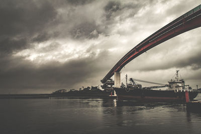 Low angle view of bridge against cloudy sky