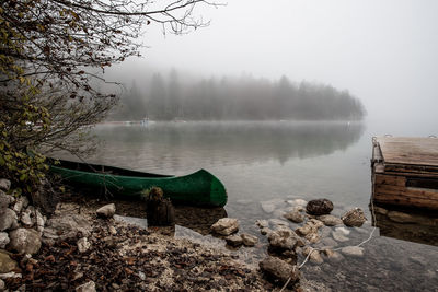 Scenic view of lake against sky during foggy weather