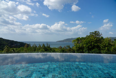 Scenic view of swimming pool by sea against sky