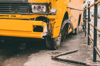 Accident on the road in city with shuttle bus. damaged yellow bus on sidewalk. damaged headlight
