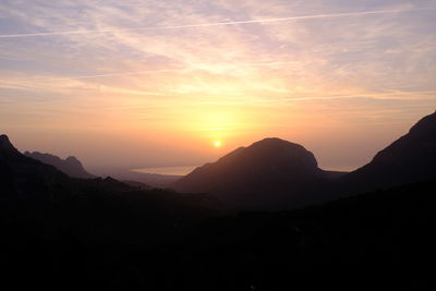 Scenic view of silhouette mountains against sky during sunset