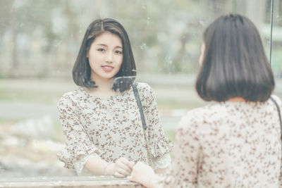 Rear view of young woman reflecting on mirror