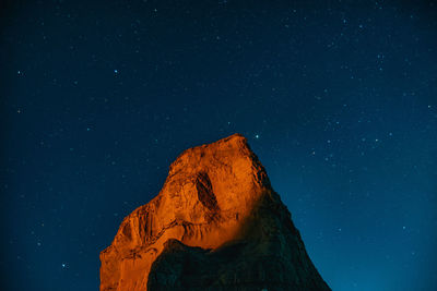 Low angle view of rock formations against sky at night