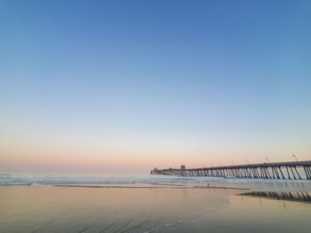 Scenic view of beach against clear sky during sunset