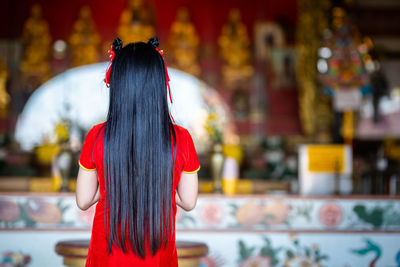 Rear view of girl standing at temple