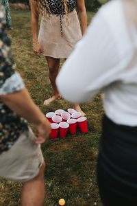 People standing around disposable cups on lawn