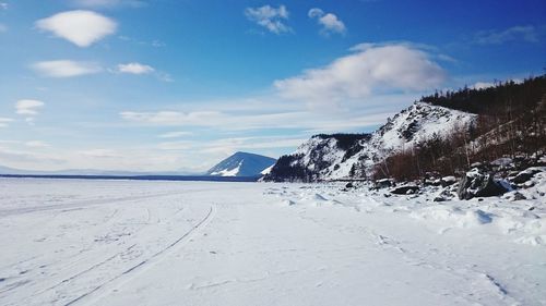 Scenic view of frozen landscape against blue sky