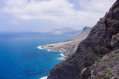 Scenic view of sea and mountains against sky