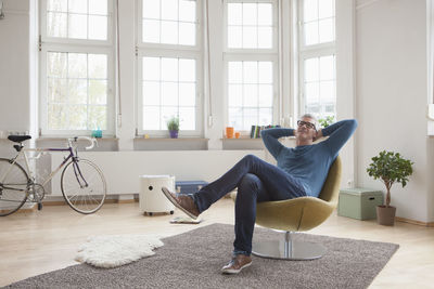 Relaxed mature man at home sitting in chair