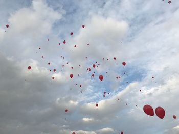 Low angle view of balloons flying against sky