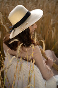 Rear view of woman wearing hat on field