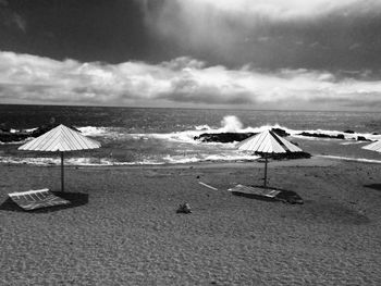 Scenic view of beach against cloudy sky