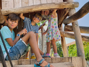 Portrait of siblings sitting on railing
