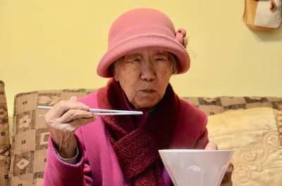 Portrait of senior woman eating food at home