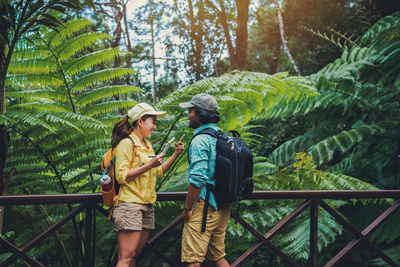 Full length of young couple standing in forest