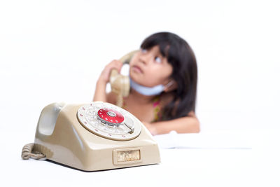 Mid adult woman using smart phone against white background