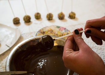 Cropped hands of woman making dessert on table