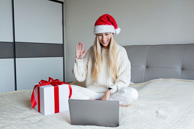 Happy woman celebrating friends with video call. christmas online holiday celebration, new year