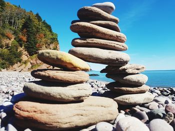 Stack of stones on beach against sky