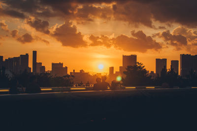 Silhouette buildings against sky during sunset