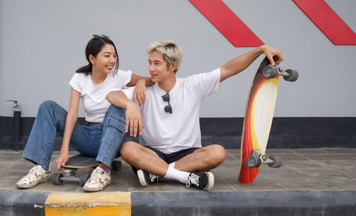 Young couple sitting on the wall