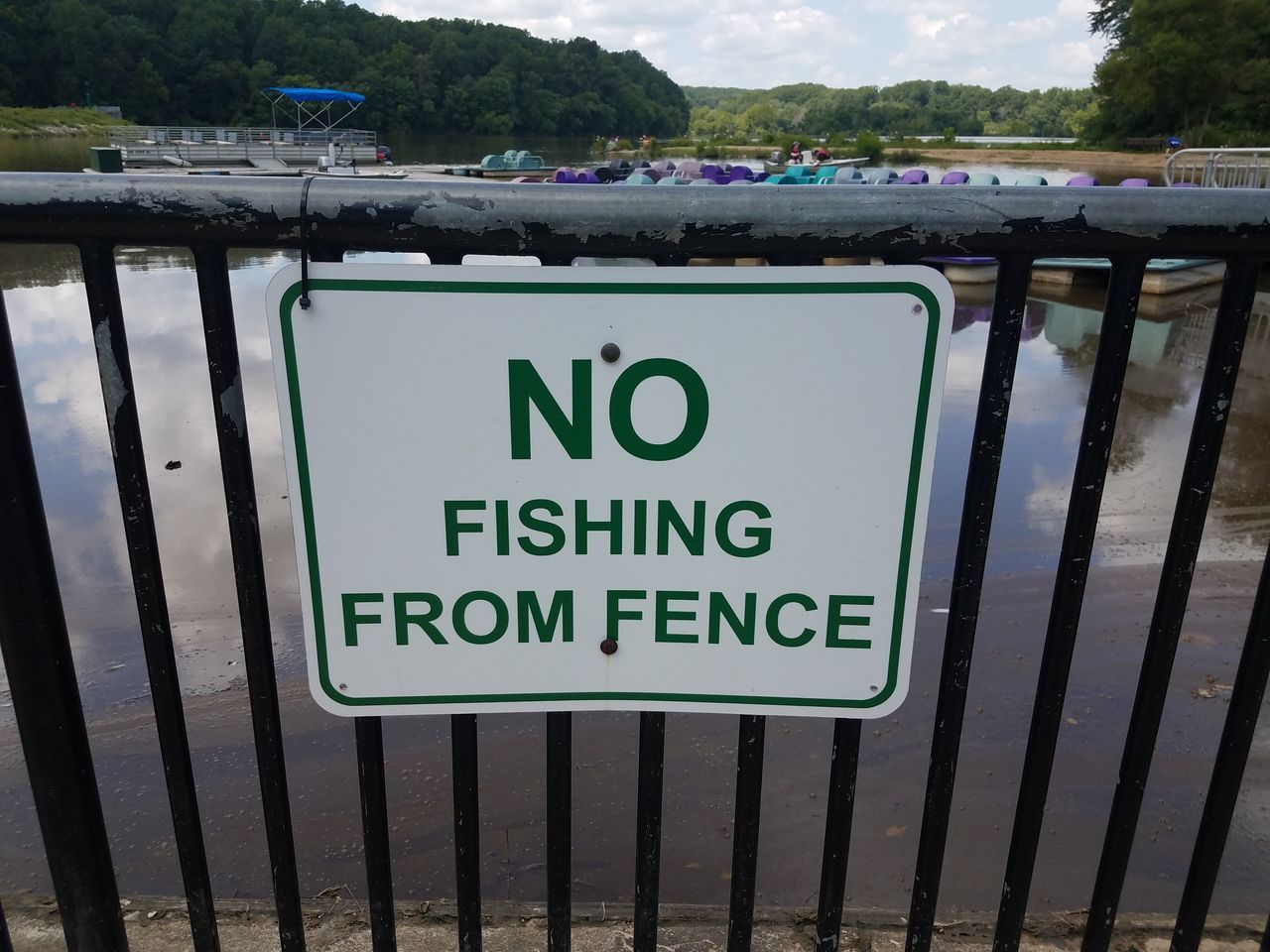 CLOSE-UP OF WARNING SIGN BY RAILING