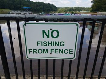 Close-up of warning sign on railing